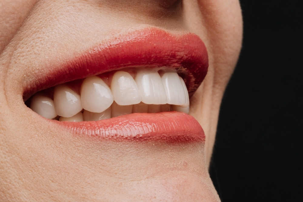 Image of a modern and clean dental office reception area with friendly staff greeting a new patient. The environment should feel welcoming and high-tech, subtly conveying the idea of a "premier dentist". No text on the image.